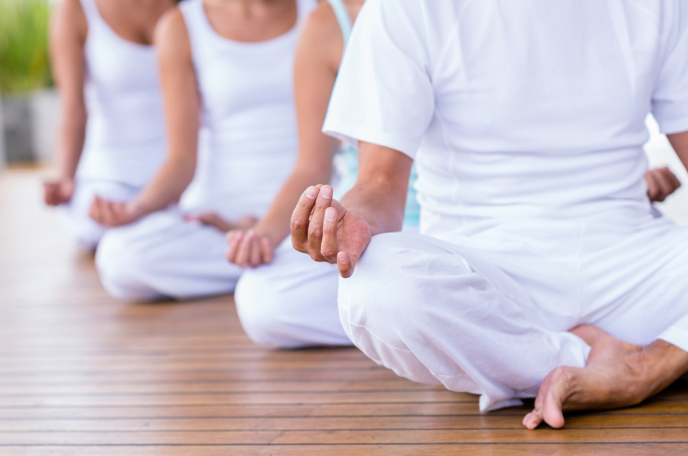 Group of peaceful people meditating  in a yoga studio